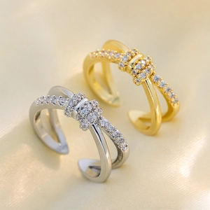 Double-layered crisscross bow rings in gold and silver with cubic zirconia accents