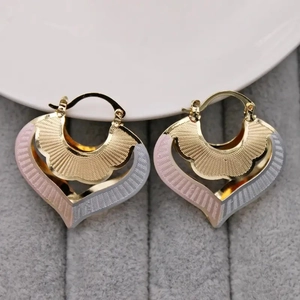Three-tone heart-shaped hoop earrings with layered etched textures on velvet background