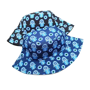 Detail view of foldable bucket hats featuring evil eye and hamsa hand cultural patterns