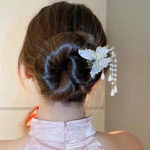 Detail einer Schmetterlings-Haarnadel mit Perlenquasten an einer eleganten Hochsteckfrisur