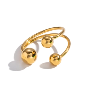 Detail view of gold polished ring featuring three spheres on a spiral open band