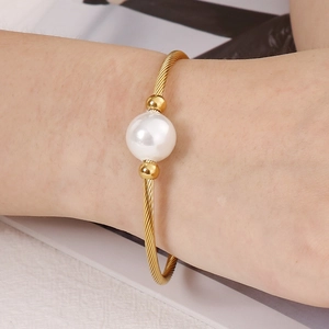 Bracelet minimaliste en fil d'acier inoxydable doré avec une perle blanche centrale chic
