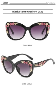 Detailed view of cat eye sunglasses with pink floral ornaments and golden leaf accents