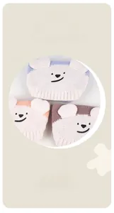 Detailed view of plush bear-themed pet hats in blue, orange, and brown coral fleece material