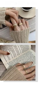 Macro detail of three-piece vintage gold-plated rings set with white enamel inlay