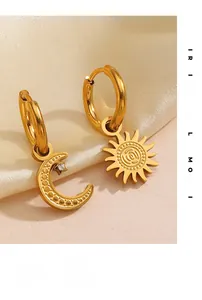 Close-up of gold asymmetrical sun and moon earrings with crystal and textured details