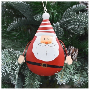 Gros plan d'une cloche Père Noël en fer peint suspendue à un sapin de Noël vert