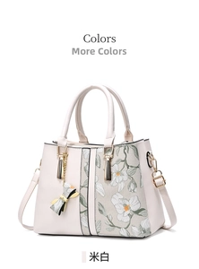 Close-up of off-white tote bag featuring delicate floral print and golden chain bow charm
