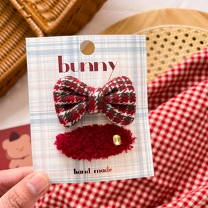 Detail of red plaid bow and plush oval hair clip with gold rhinestone for girls