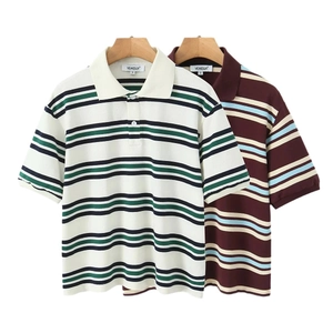 T-shirt polo retrò a righe nei colori crema verde e bordeaux appese su grucce