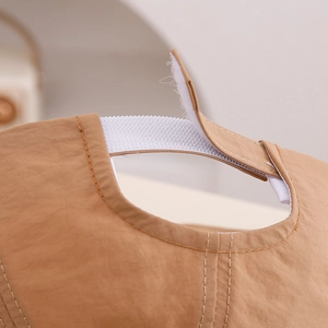 Detail of adjustable velcro strap on brown baby sun hat showing stitching and material