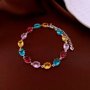 Detailed macro of silver bracelet featuring multi-colored oval-cut cubic zirconia gemstones