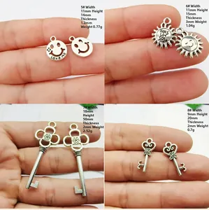 Détails de divers pendentifs en argent montrant les dimensions tenus dans la main