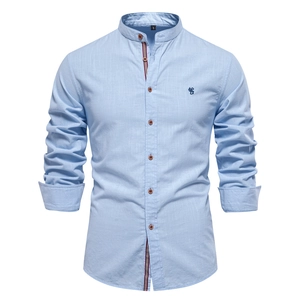 Vue détaillée d'une chemise en lin bleu clair avec ruban tricolore et broderie