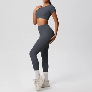 Détail d'un ensemble de yoga gris foncé avec legging taille haute et crop top court