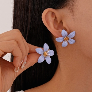 Close-up of lavender five-petal flower earring with golden center on model ear