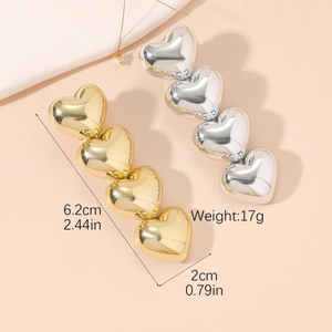 Detailed view of polished heart-shaped hair clips in gold and silver showing dimensions