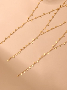 Macro detail of 18K gold-plated long Y-necklace with shiny cascading disc charms