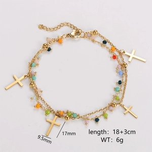 Detail view of a double-layered gold chain bracelet with colorful beads and cross charms