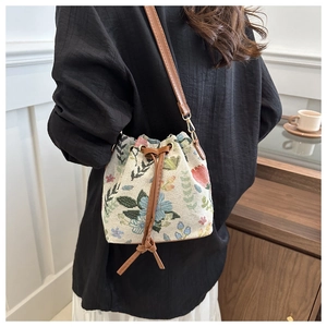 Ethnic style drawstring bucket bag with floral embroidery and brown leather strap