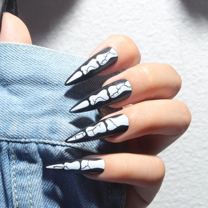 Gothic stiletto press-on nails with white skeleton bone pattern on glossy black finish