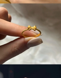 Macro detail of 18K gold plated bow ring with beaded texture and adjustable band