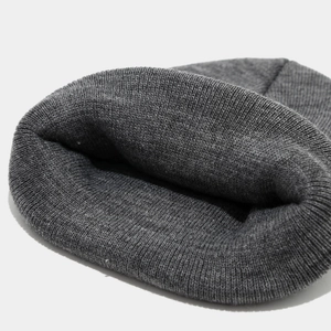 Vue macro détaillée de la texture tricotée gris foncé et de l'ourlet du bonnet