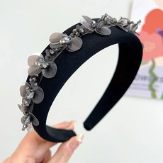 Macro detail of black velvet headband featuring grey sequin floral embroidery and beads