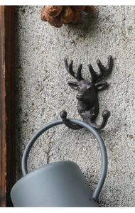 Detailaufnahme eines Hirschkopf-Haken aus Gusseisen mit Tasse an Strukturwand