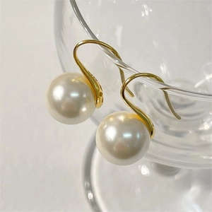 Macro shot of 925 sterling silver pearl hook earrings with S925 hallmark on metal