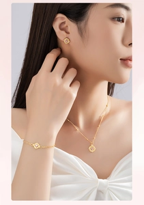Detailansicht des goldenen Schmucksets mit rosa Herzsteinen an einem Modell