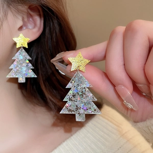 Detail of Christmas tree earrings with silver glitter and golden star on silver needle studs