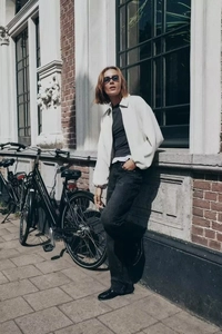 Détail d'une veste minimaliste blanc crème avec fermeture éclair et style urbain décontracté