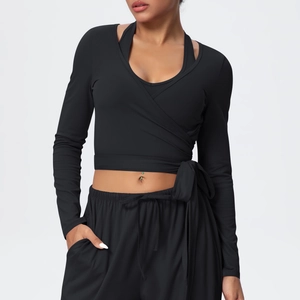 Detail of black cross-wrap yoga top with waist ties and high-waisted jogger set