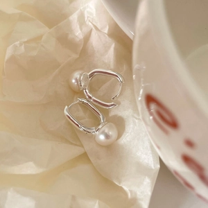 Close-up of S925 sterling silver geometric U-shaped hooks with elegant white pearls