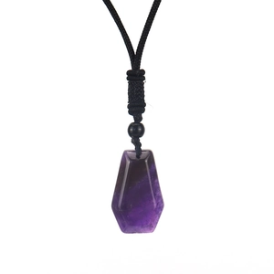 Detailed macro shot of a hexagonal purple amethyst pendant with a black woven cord