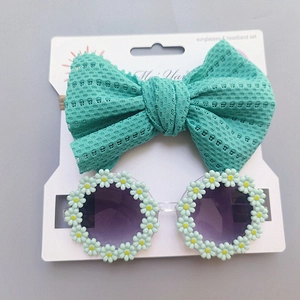 Detail of baby daisy sunglasses and mesh bow headband set on display card