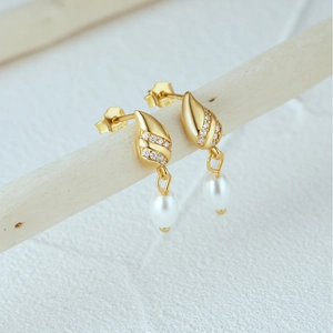 Detail of s925 silver leaf pearl earrings with gold finish and zircon micro-inlay