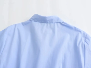 Detailed close-up of light blue cotton poplin shirt collar and back shoulder stitching