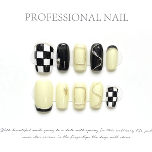 Detail of handmade press-on nails featuring black and white checkerboard with gold wire art