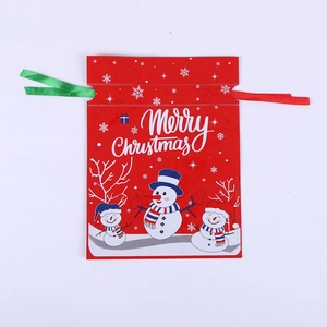 Detail of red Christmas drawstring gift bag with snowman pattern and Merry Christmas text