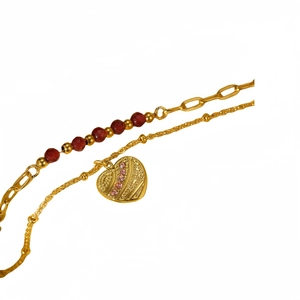 Double-layered gold stainless steel bracelet with red beads and a heart relief pendant