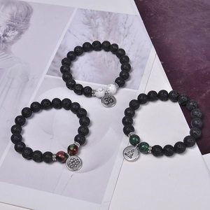 Lava stone bead bracelet set with lotus and OM charms on a stylish lifestyle background