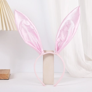 Close-up of pink satin bunny ears headband with glossy texture and fabric-wrapped band