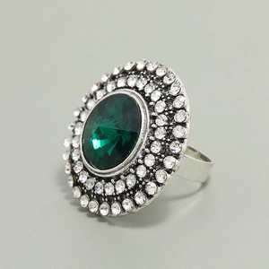 Macro detail of a vintage silver cocktail ring featuring a deep green oval gemstone