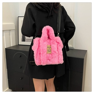 Detail of pink faux fur tote bag with Have a Nice Day tag and black strap