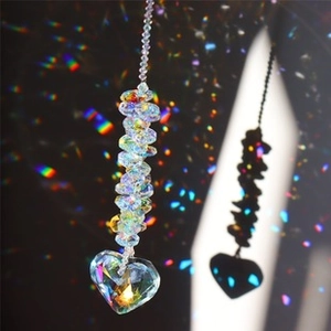 Detailed view of crystal suncatcher with heart prism reflecting rainbow light