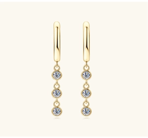 Macro detail of elegant gold tassel earrings featuring triple-stacked round moissanite stones