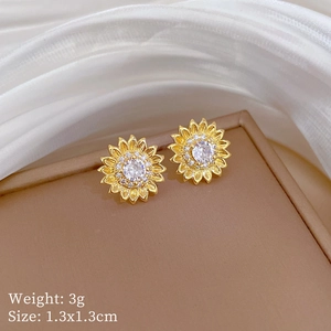 Detailed view of gold sunflower earrings with cubic zirconia on a luxury jewelry box