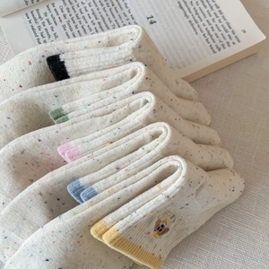 Close-up of knit cotton socks with colorful speckled patterns and vibrant contrast toes
